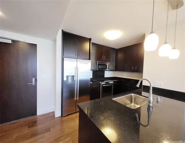 a kitchen with stainless steel appliances granite countertop a sink a stove and refrigerator