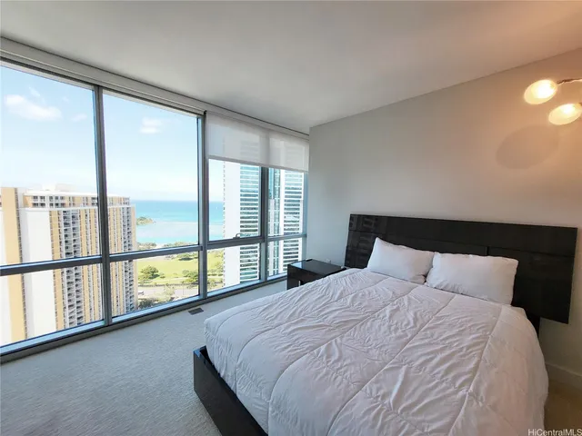 a large bed sitting in a bedroom next to a large window