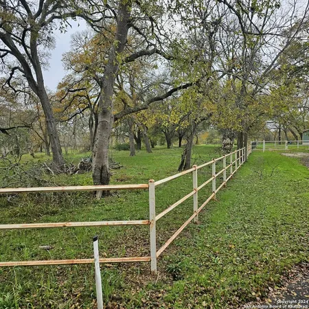 a view of a yard with wooden fence