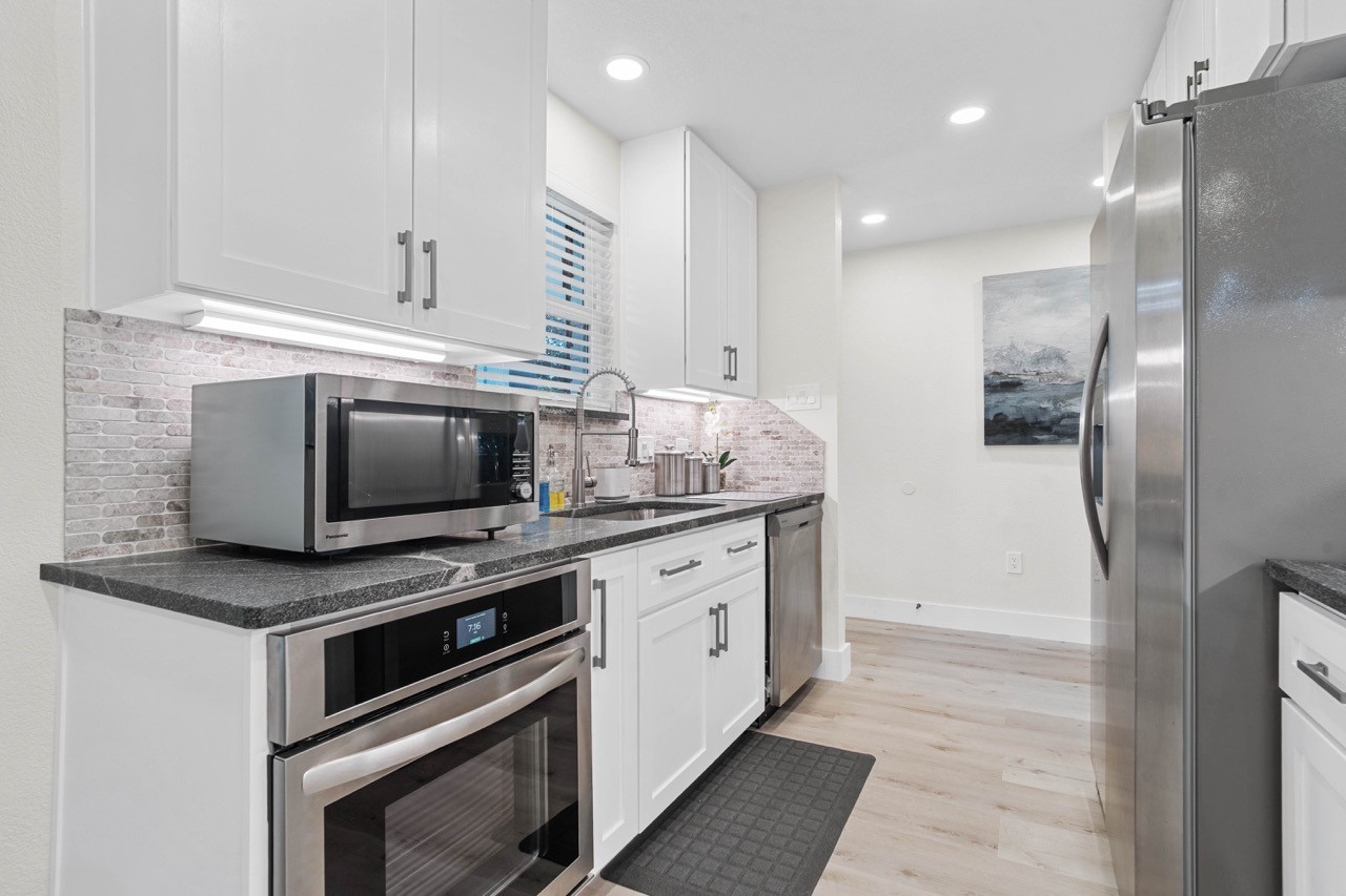 3138 Sunbeam Street Houston, TX 77051 - Photo 20 of 50 Sleek stainless appliances and marbled-mosaic backsplash details bring timeless sophistication to this beautifully updated kitchen.