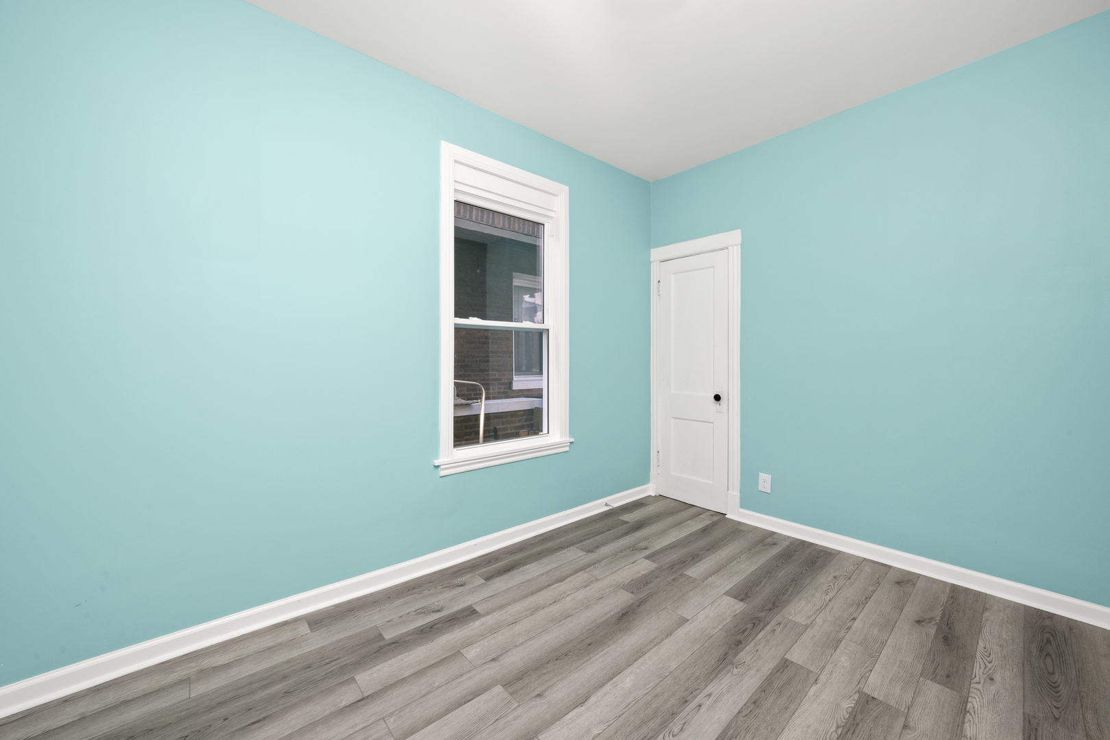 7128 South May Street Chicago, IL 60621 - Photo 15 of 32 an empty room with wooden floor and a window