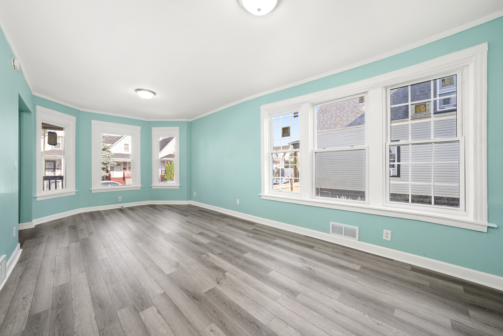 7128 South May Street Chicago, IL 60621 - Photo 2 of 32 an empty room with wooden floor and windows