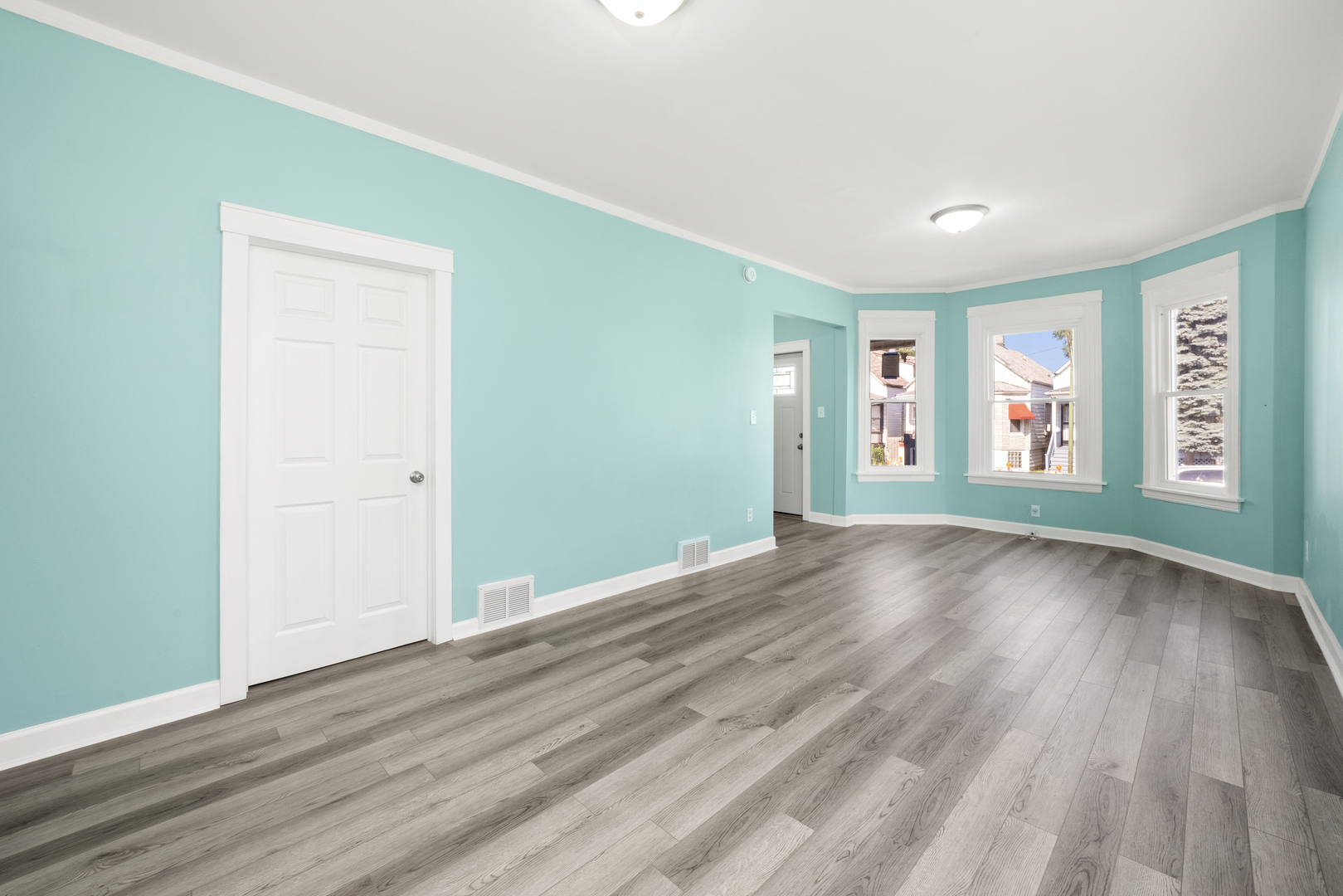 7128 South May Street Chicago, IL 60621 - Photo 3 of 32 an empty room with wooden floor and windows