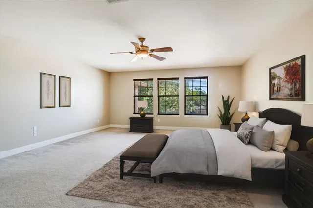 an empty room with windows and ceiling fan