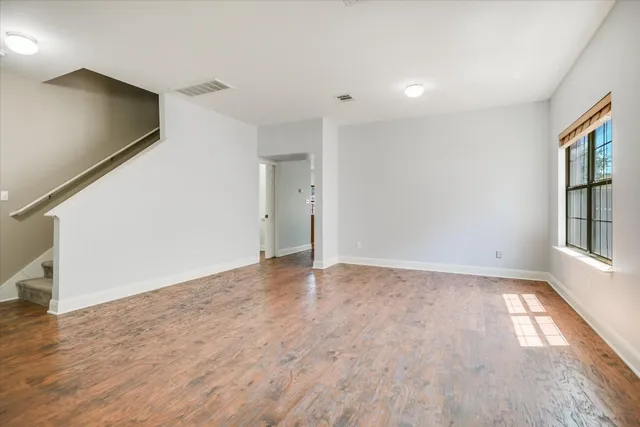wooden floor in an empty room with a window