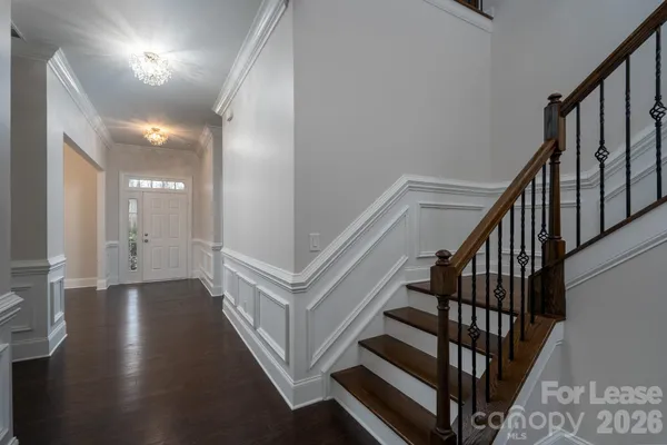 a view of staircase with lots of frames on wall and wooden floor