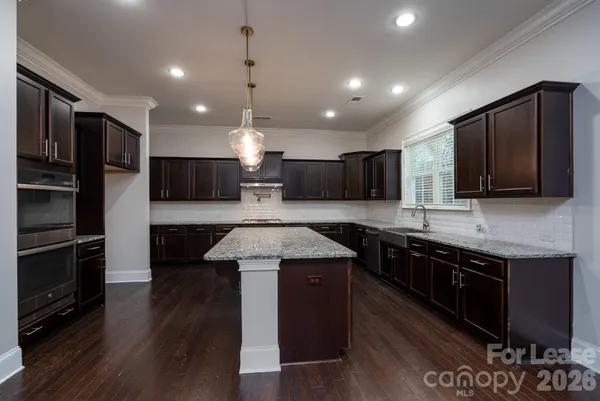 a large kitchen with stainless steel appliances and wooden cabinets