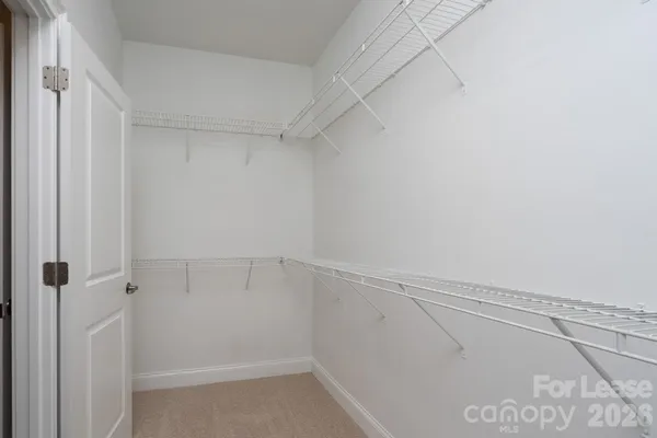 a view of walk in closet with empty racks