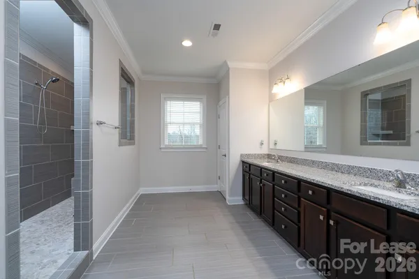 a spacious bathroom with double vanity and a mirror
