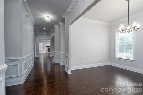 a view of a hallway with wooden floor and a window