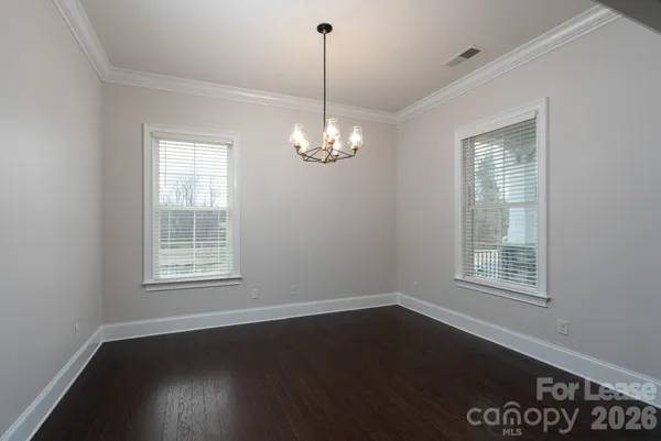 a view of a room with wooden floor and windows