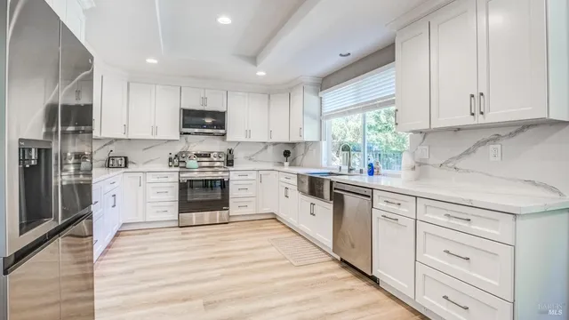 a kitchen with white cabinets and white appliances