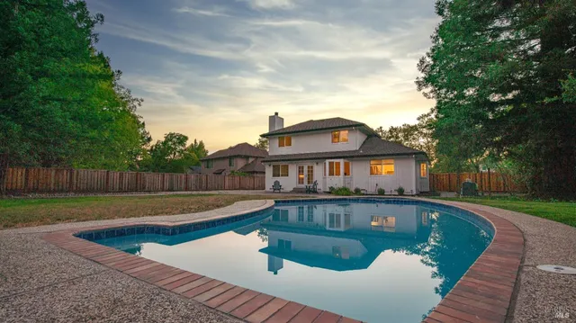 a front view of a house with swimming pool having outdoor seating