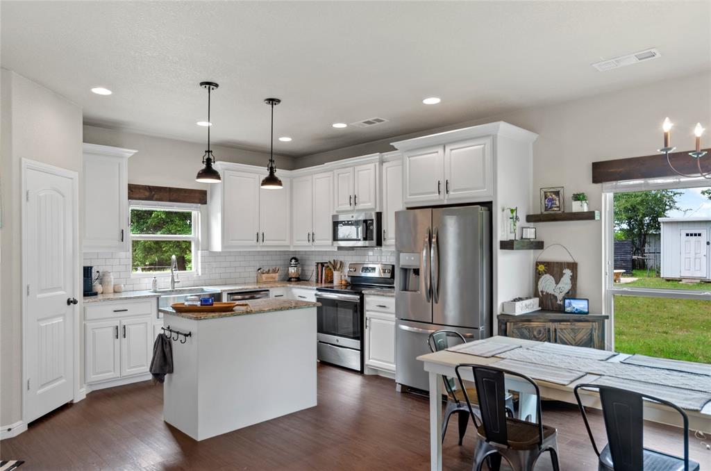 6093 Farm To Market Road 730 North Decatur, TX 76234 - Photo 8 of 28 a kitchen with a refrigerator a stove a sink a dining table and chairs