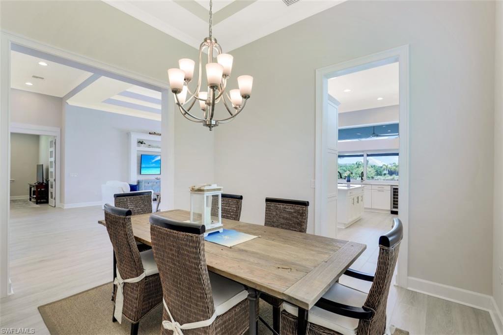 5771 Clarendon Drive Naples, FL 34113 - Photo 12 of 33 a view of a dining room with furniture and wooden floor