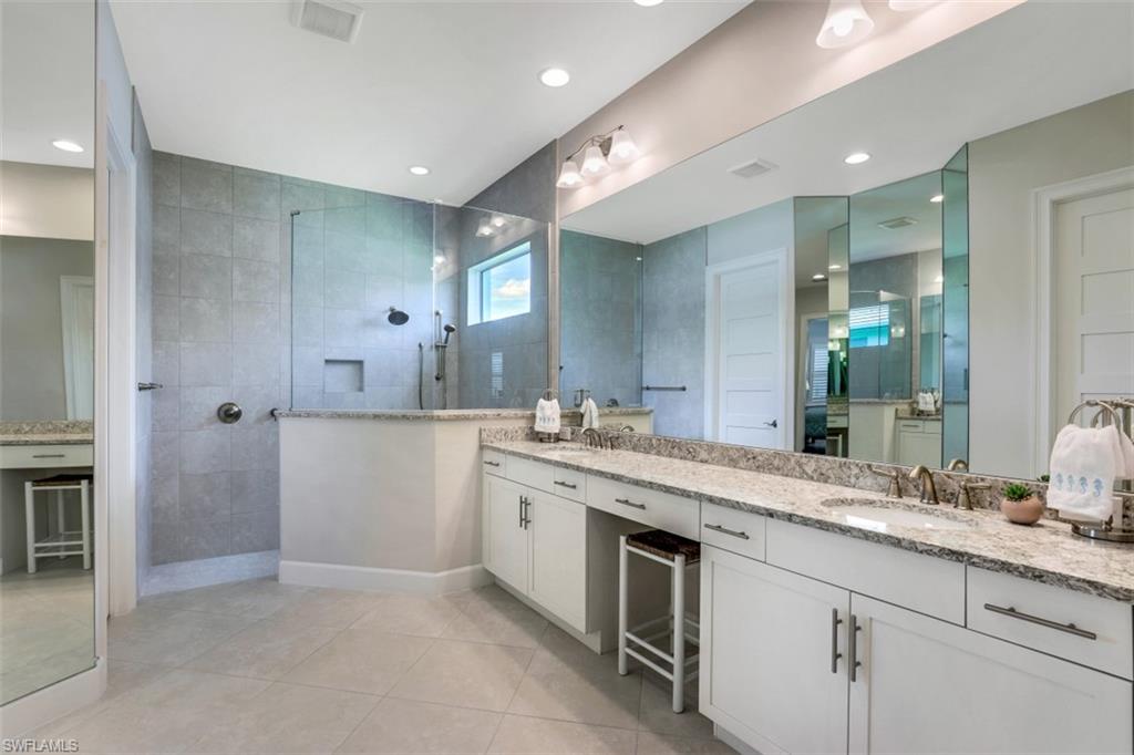 5771 Clarendon Drive Naples, FL 34113 - Photo 14 of 33 a spacious bathroom with a granite countertop sink mirror and shower