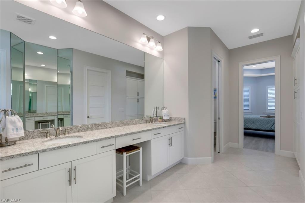 5771 Clarendon Drive Naples, FL 34113 - Photo 15 of 33 a bathroom with a double vanity sink and a mirror