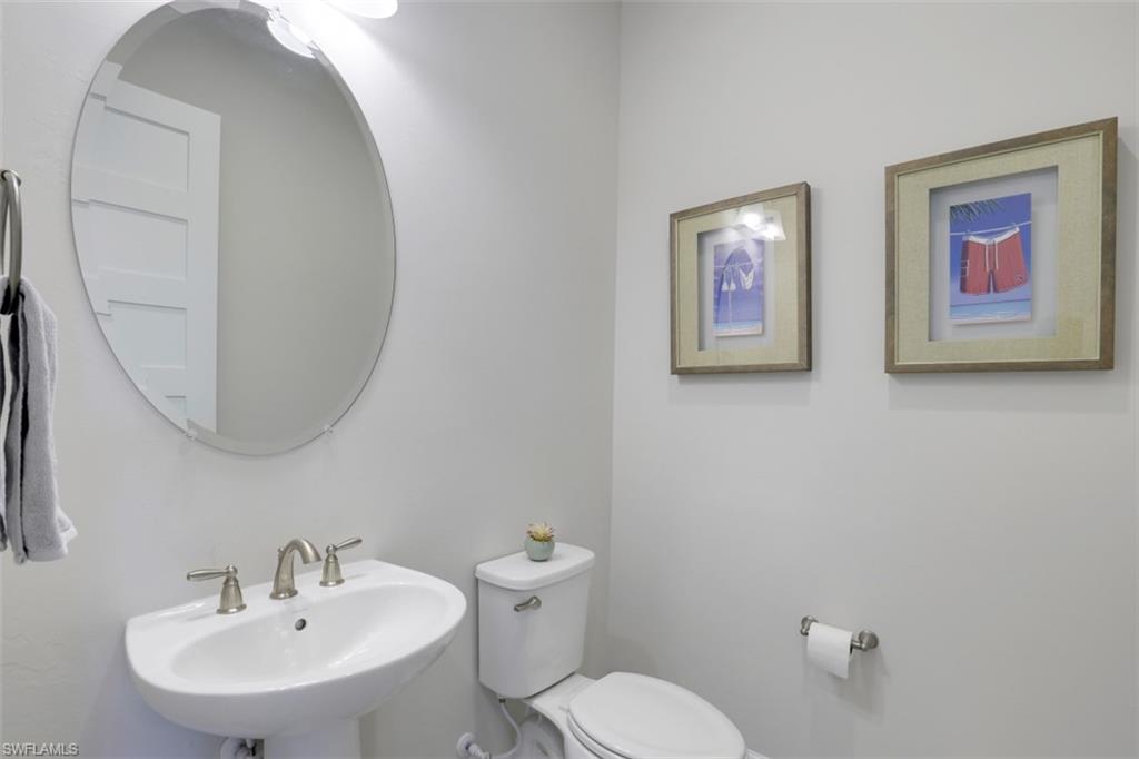 5771 Clarendon Drive Naples, FL 34113 - Photo 19 of 33 a bathroom with a toilet a sink and mirror