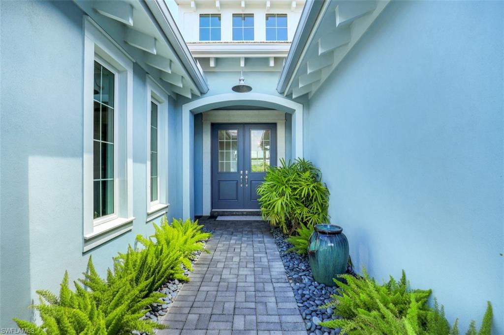 5771 Clarendon Drive Naples, FL 34113 - Photo 2 of 33 a front view of a house with a garden
