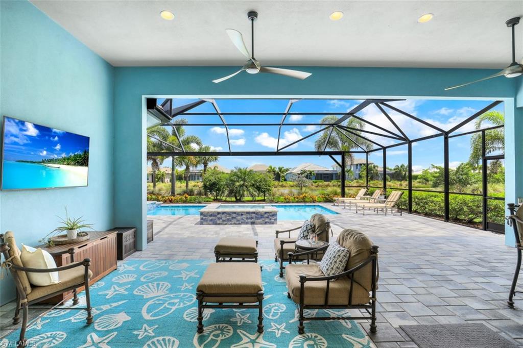 5771 Clarendon Drive Naples, FL 34113 - Photo 22 of 33 a living room with furniture and a floor to ceiling window
