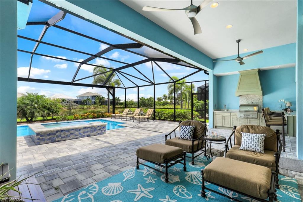 5771 Clarendon Drive Naples, FL 34113 - Photo 24 of 33 a living room with patio furniture and a floor to ceiling window