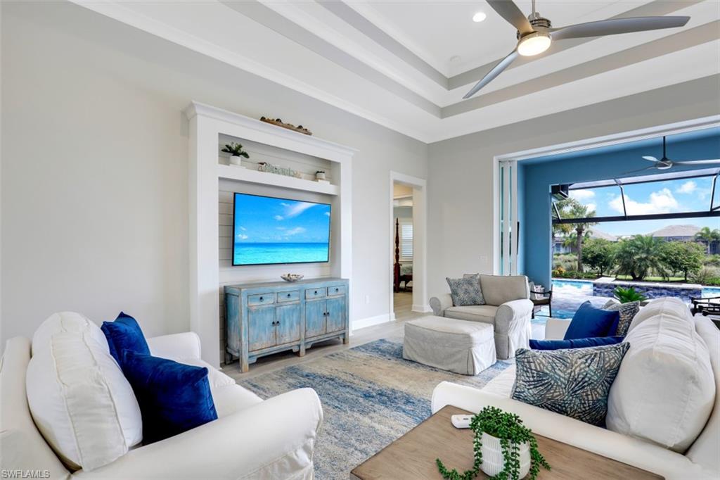 5771 Clarendon Drive Naples, FL 34113 - Photo 5 of 33 a living room with furniture and a flat screen tv