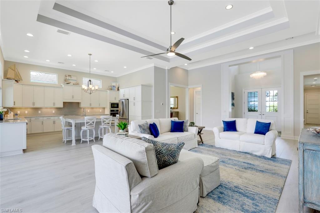 5771 Clarendon Drive Naples, FL 34113 - Photo 6 of 33 a living room with furniture kitchen view and a wooden floor