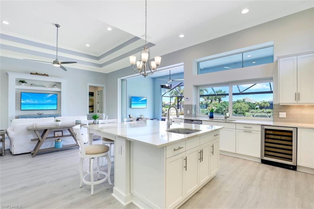 5771 Clarendon Drive Naples, FL 34113 - Photo 10 of 33 a kitchen with a sink stove and wooden floor