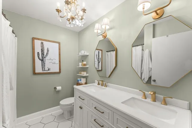 a bathroom with a double vanity sink mirror and toilet