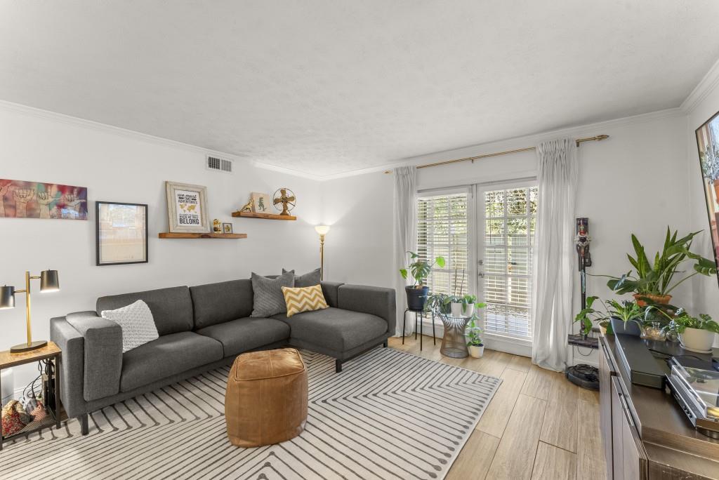 1150 Collier Road Northwest, Unit J18 Atlanta, GA 30318 - Photo 2 of 32 a living room with furniture and a wooden floor