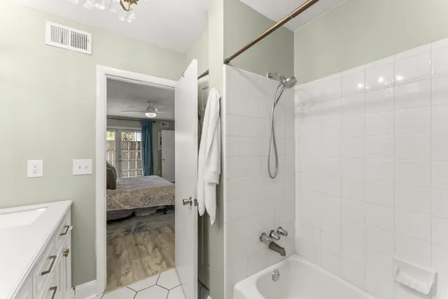 a bathroom with a tub shower vanity and a sink