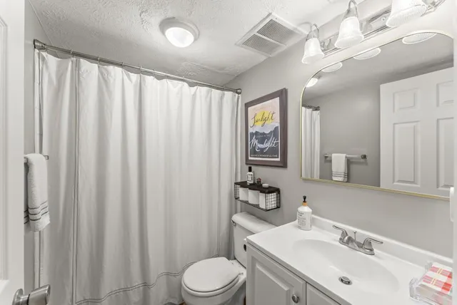 a bathroom with a sink vanity mirror and toilet