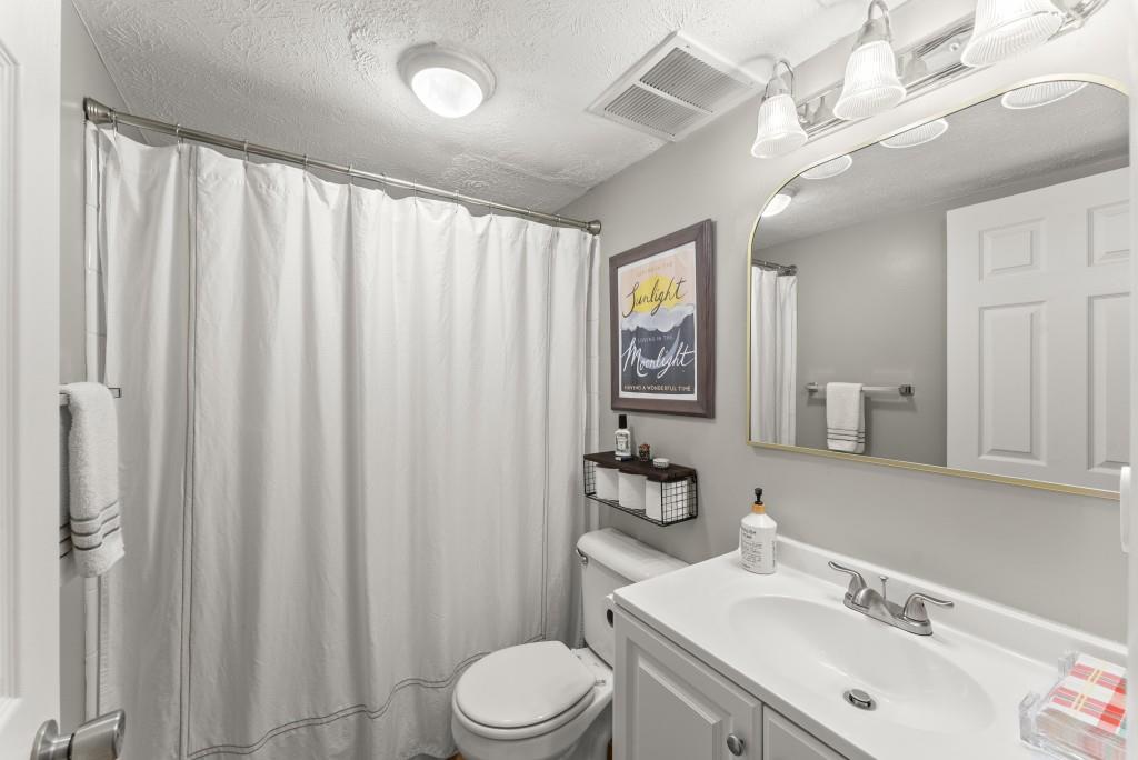 1150 Collier Road Northwest, Unit J18 Atlanta, GA 30318 - Photo 24 of 32 a bathroom with a sink vanity mirror and toilet