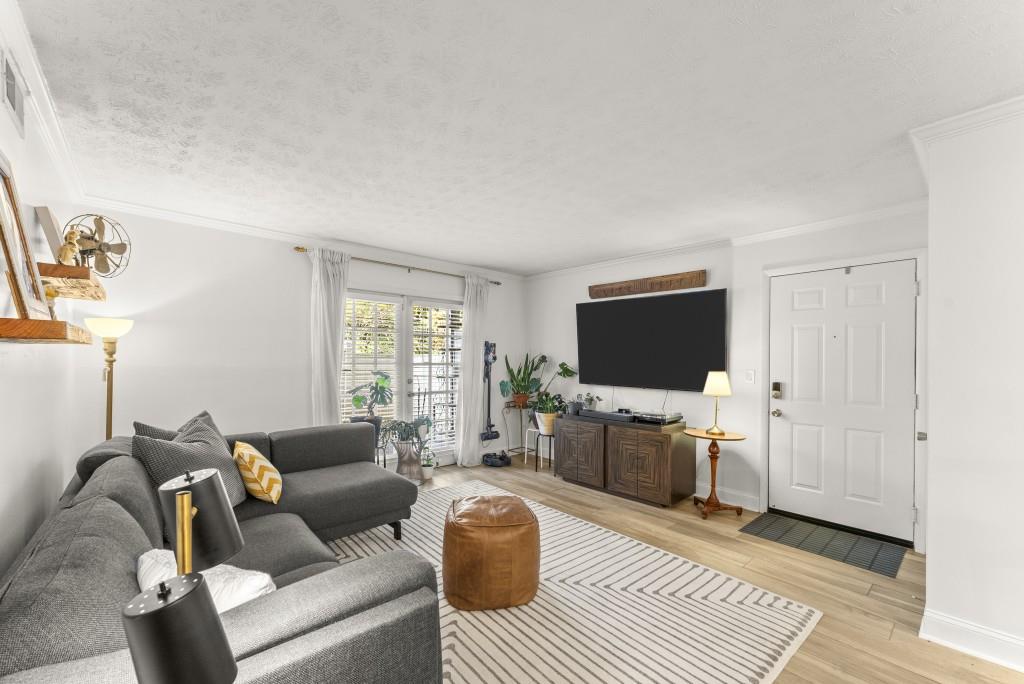 1150 Collier Road Northwest, Unit J18 Atlanta, GA 30318 - Photo 9 of 32 a living room with furniture and a flat screen tv