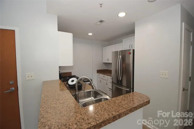 a kitchen with a sink refrigerator and microwave