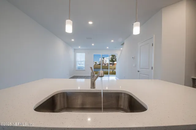 a kitchen with kitchen island a sink and a refrigerator
