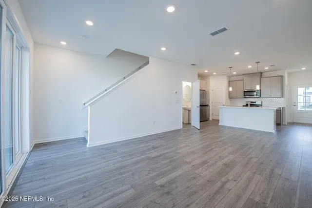 a view of kitchen with wooden floor and electronic appliances
