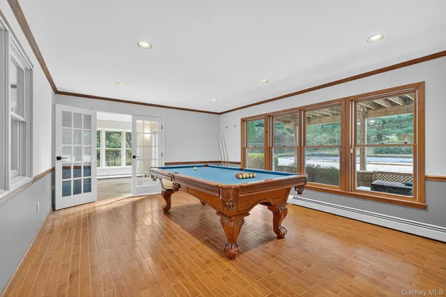 a room with pool table and wooden floor