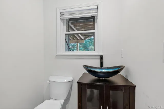 a bathroom with a toilet a sink and a window