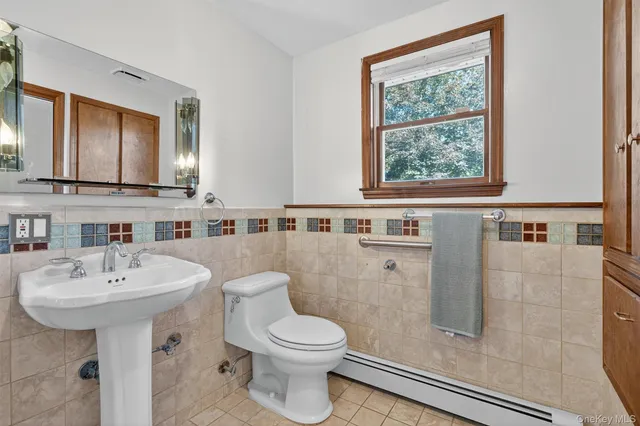 a bathroom with a sink a toilet and mirror