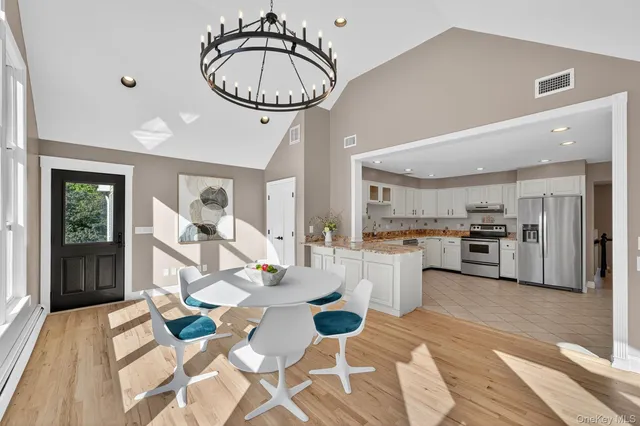 a kitchen with a sink dishwasher a stove a microwave oven with a dining table and chairs