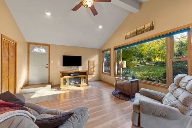 a living room with furniture flat screen tv and a large window