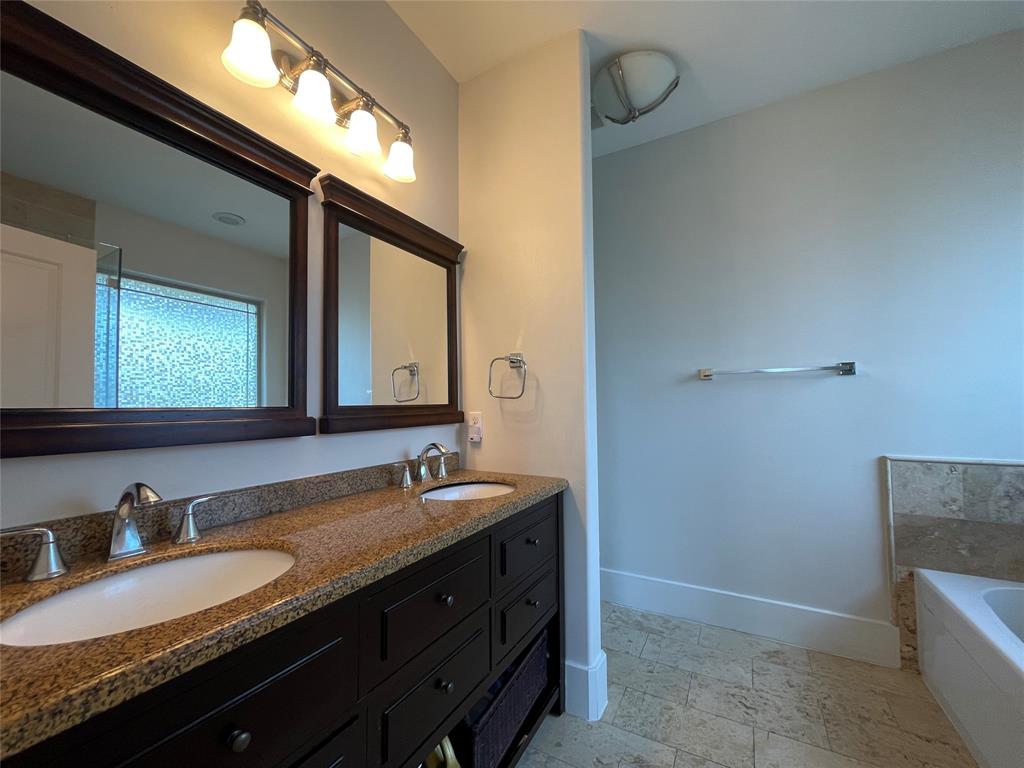 1007 Taulbee Lane, Unit B Austin, TX 78757 - Photo 19 of 36 Full bath featuring double vanity, a garden tub, and light stone finish flooring