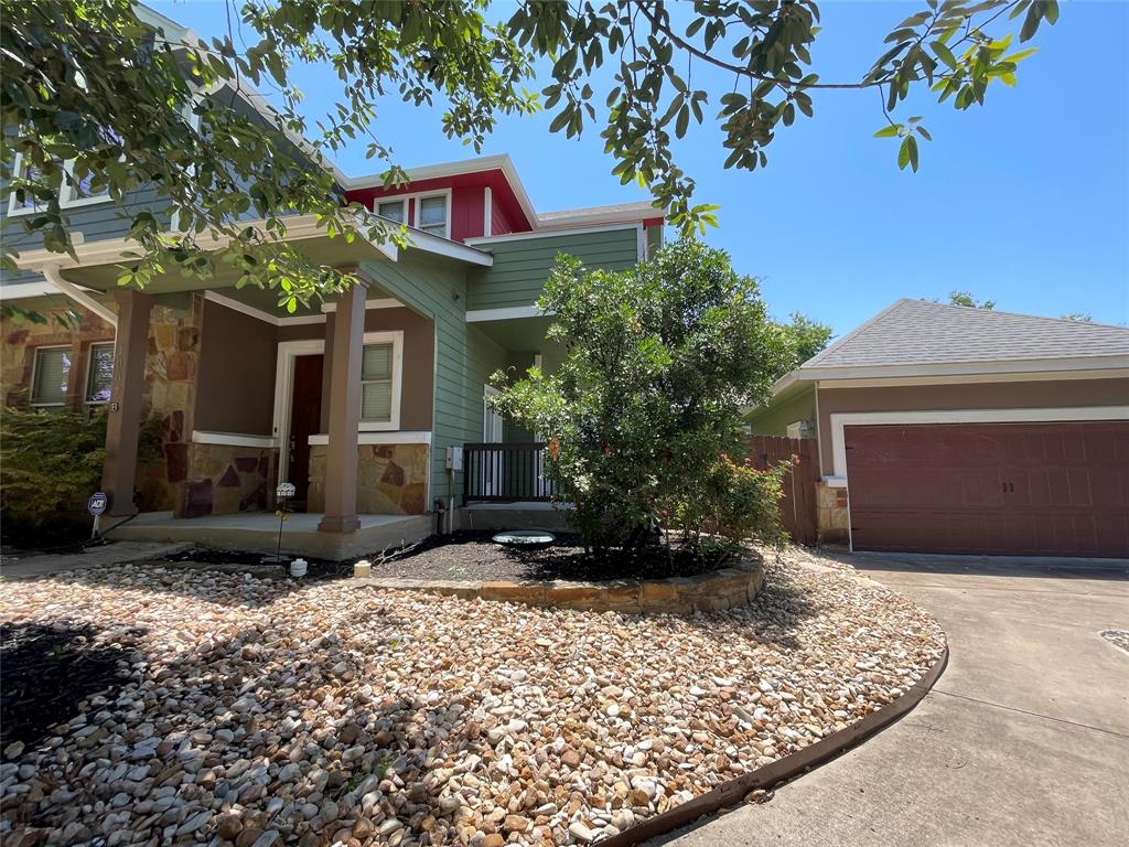 1007 Taulbee Lane, Unit B Austin, TX 78757 - Photo 2 of 36 View of front facade with stone siding, covered porch, concrete driveway, and a garage