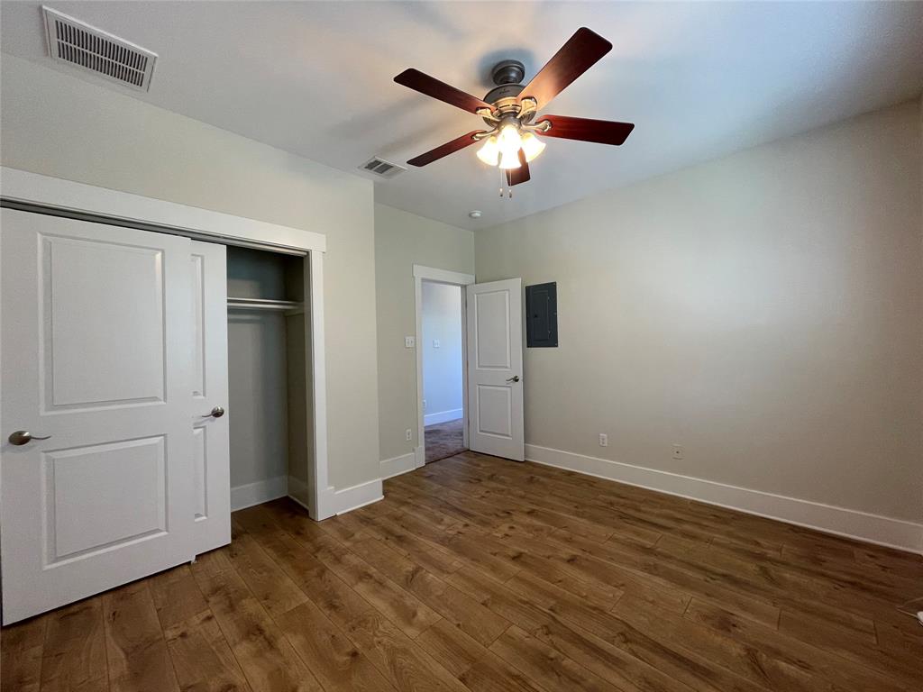 1007 Taulbee Lane, Unit B Austin, TX 78757 - Photo 22 of 36 Unfurnished bedroom featuring dark wood finished floors, a closet, a ceiling fan, and electric panel
