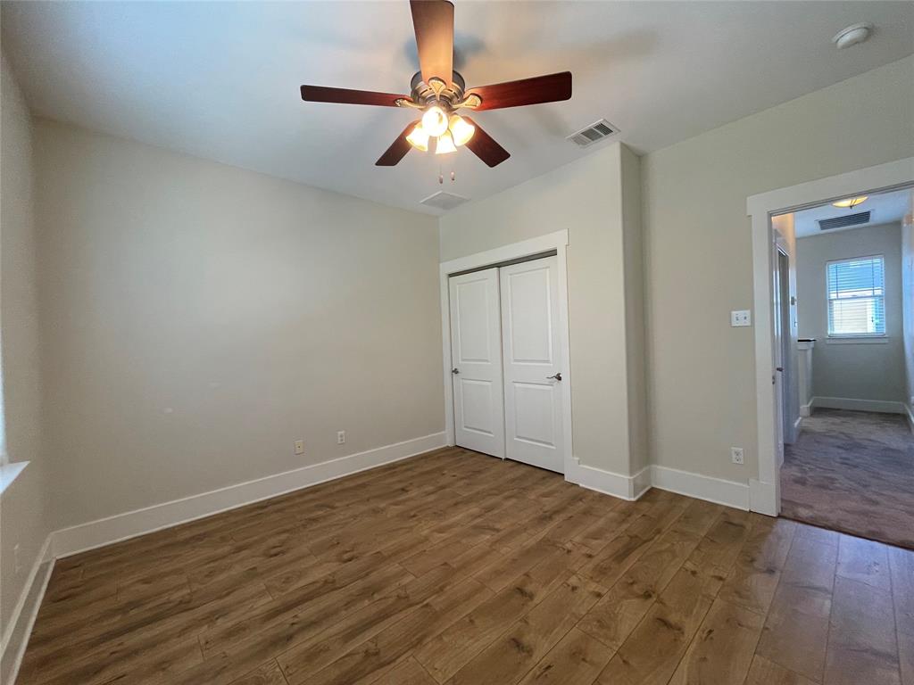 1007 Taulbee Lane, Unit B Austin, TX 78757 - Photo 23 of 36 Unfurnished bedroom featuring dark wood finished floors, a ceiling fan, and a closet