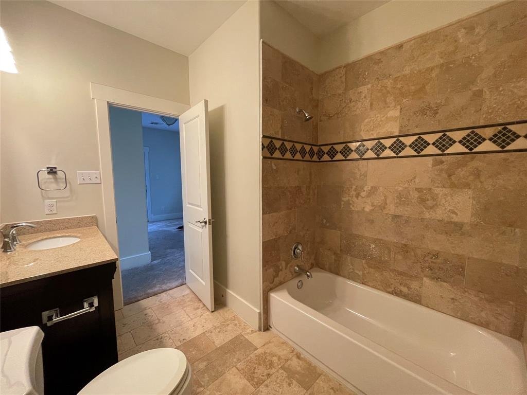 1007 Taulbee Lane, Unit B Austin, TX 78757 - Photo 28 of 36 Full bath with vanity, stone tile floors, and tub / shower combination