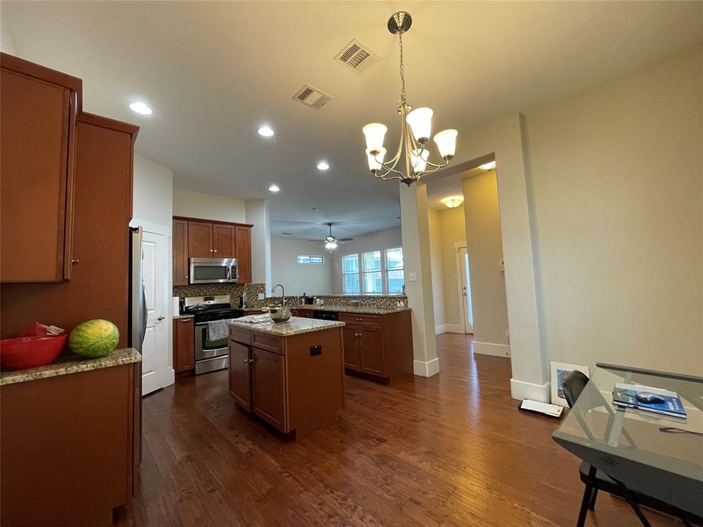 1007 Taulbee Lane, Unit B Austin, TX 78757 - Photo 8 of 36 Kitchen with a chandelier, stainless steel appliances, dark wood-style floors, and a peninsula