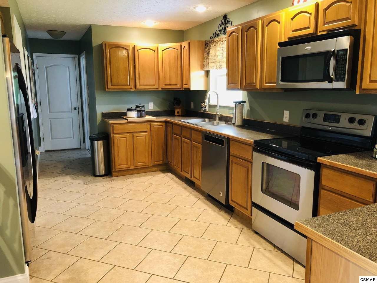 612 Chestnut Grove Road Dandridge, TN 37725 - Photo 7 of 16 a kitchen with stainless steel appliances granite countertop a stove a sink and a microwave