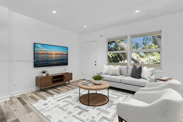 a living room with furniture a rug and a flat screen tv